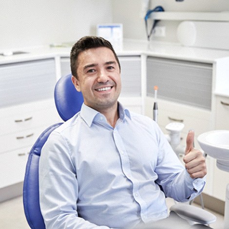 Male dental patient giving a thumbs up